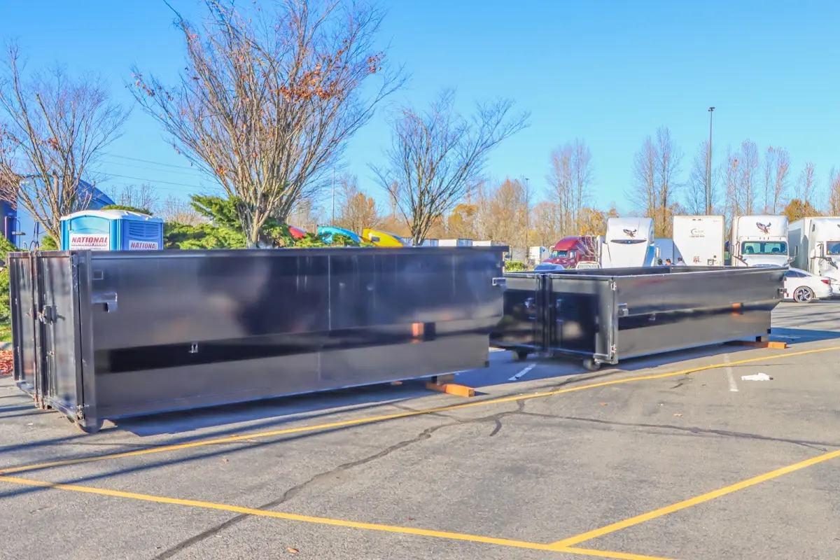 Professional dumpster rental service with roll-off container on residential driveway in Van Buren